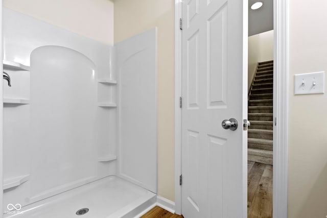 bathroom featuring hardwood / wood-style flooring and walk in shower