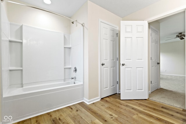 bathroom with ceiling fan, wood-type flooring, and tub / shower combination