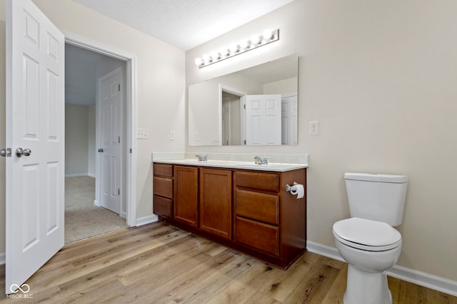 bathroom featuring vanity, hardwood / wood-style flooring, and toilet