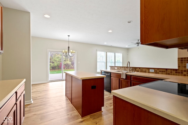 kitchen featuring black dishwasher, a kitchen island, plenty of natural light, and sink