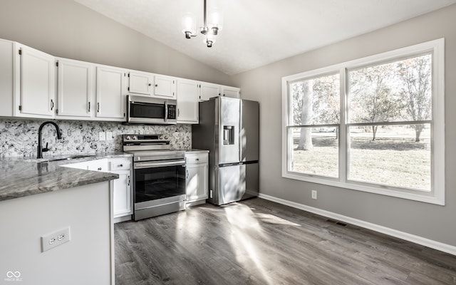 kitchen featuring light stone countertops, stainless steel appliances, sink, white cabinetry, and lofted ceiling