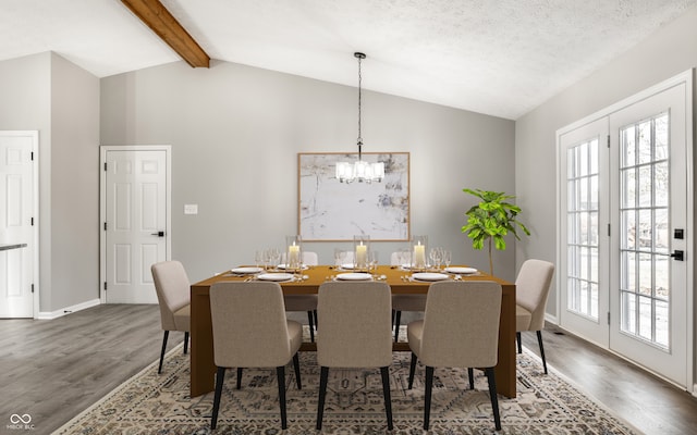 dining area featuring a textured ceiling, lofted ceiling with beams, hardwood / wood-style flooring, and a notable chandelier