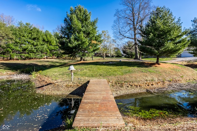 view of dock featuring a water view and a lawn