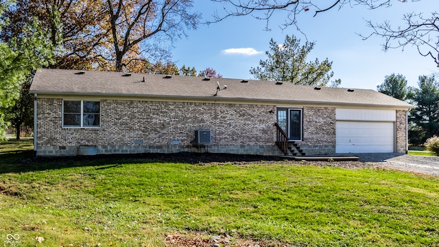 rear view of house featuring a garage and a lawn