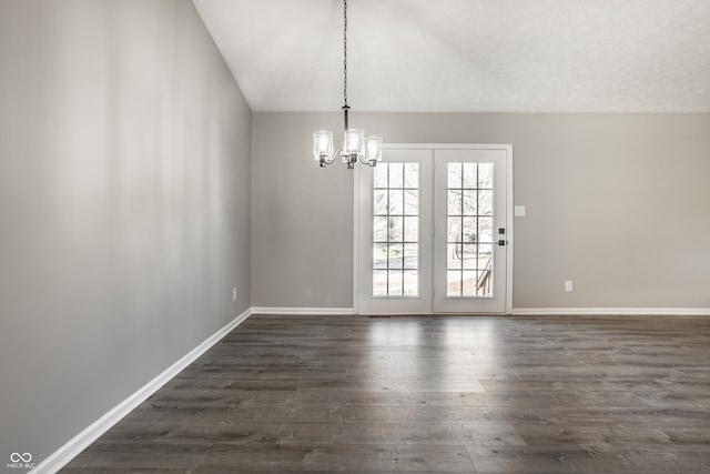 unfurnished dining area with a textured ceiling, dark wood-type flooring, and a chandelier