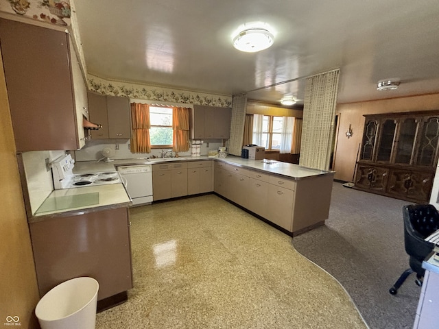 kitchen with kitchen peninsula, white appliances, and sink