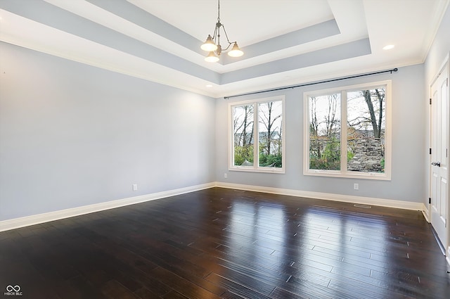 unfurnished room with dark wood-type flooring, a chandelier, a raised ceiling, and ornamental molding