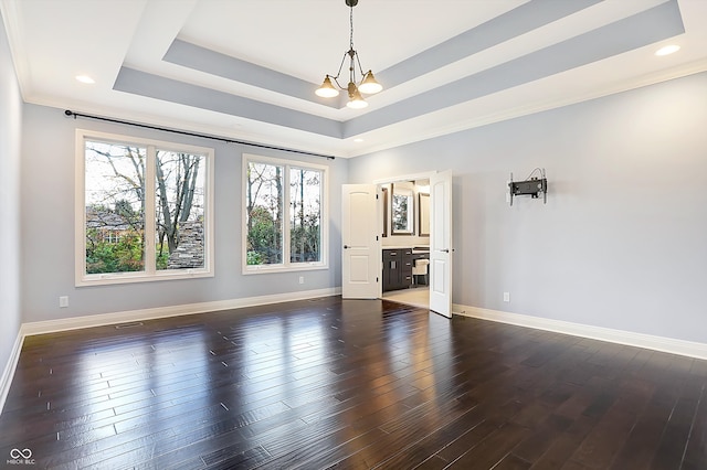 unfurnished room featuring a wealth of natural light, a notable chandelier, and dark hardwood / wood-style flooring