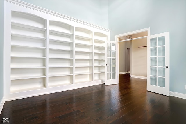 spacious closet featuring french doors, dark hardwood / wood-style floors, and a towering ceiling