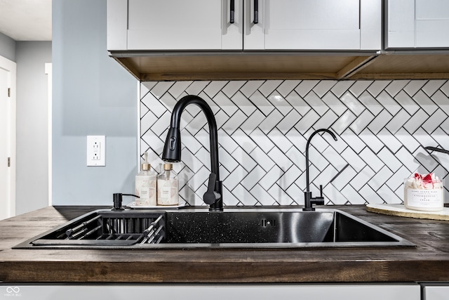 room details featuring white cabinets and sink