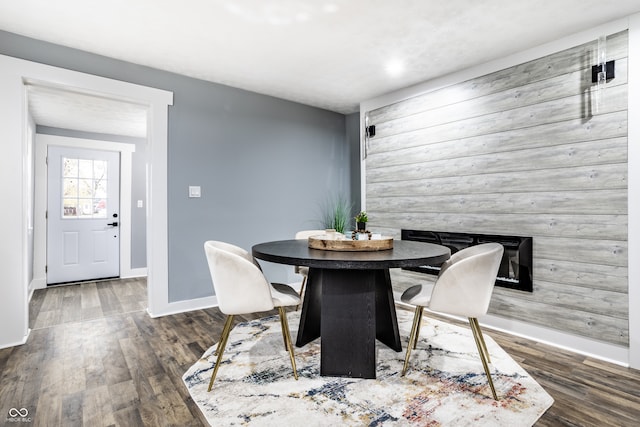 dining area featuring wooden walls and dark hardwood / wood-style floors