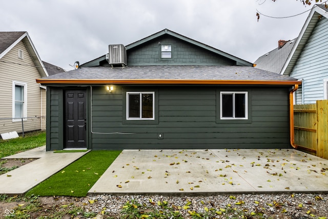 back of property with central AC unit and a patio area