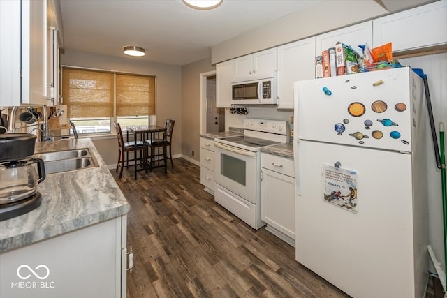 kitchen featuring dark hardwood / wood-style flooring, white cabinets, white appliances, and sink