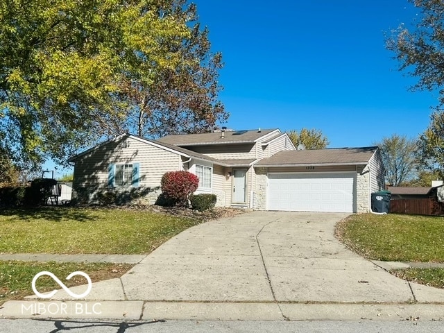 view of front of property featuring a front lawn and a garage