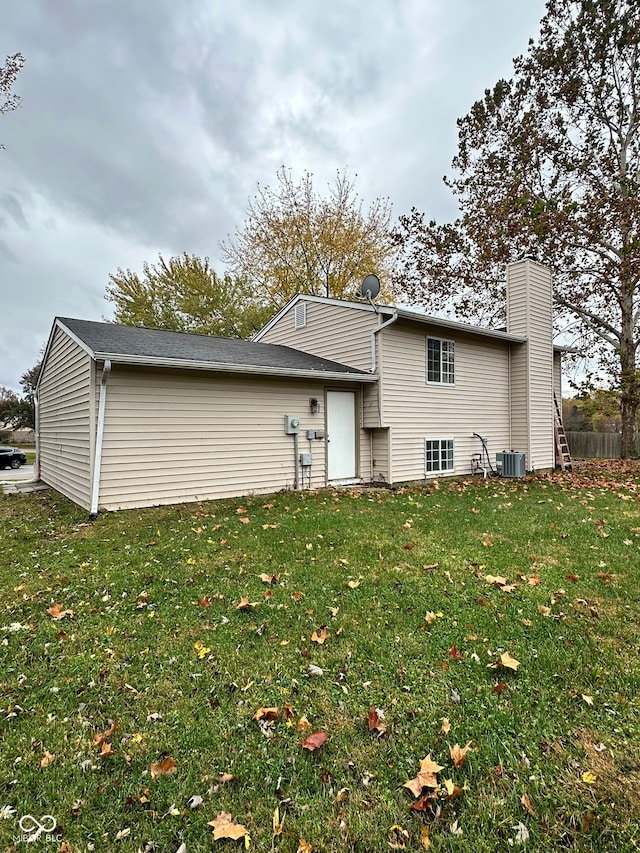 back of house featuring central AC and a yard