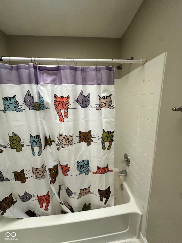 bathroom with a textured ceiling and shower / tub combo