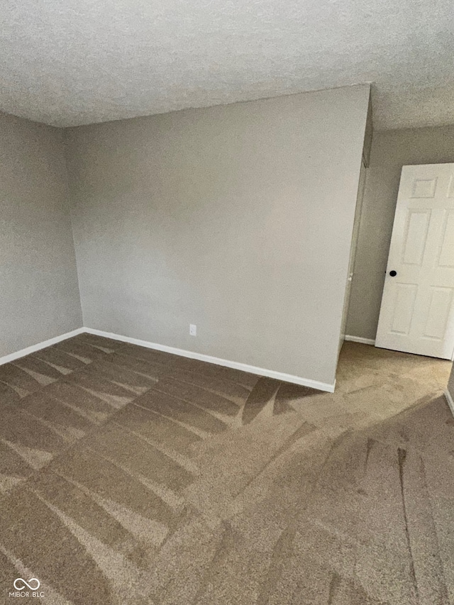 carpeted empty room with a textured ceiling