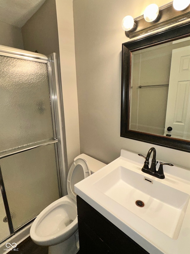 bathroom featuring walk in shower, vanity, a textured ceiling, and toilet