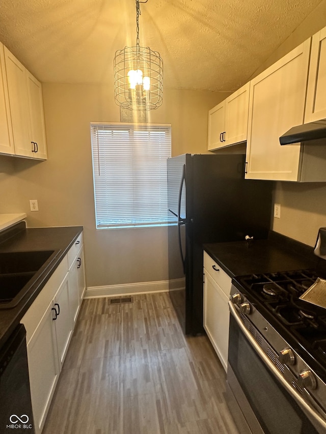 kitchen with decorative light fixtures, stainless steel gas range oven, an inviting chandelier, white cabinets, and dishwasher