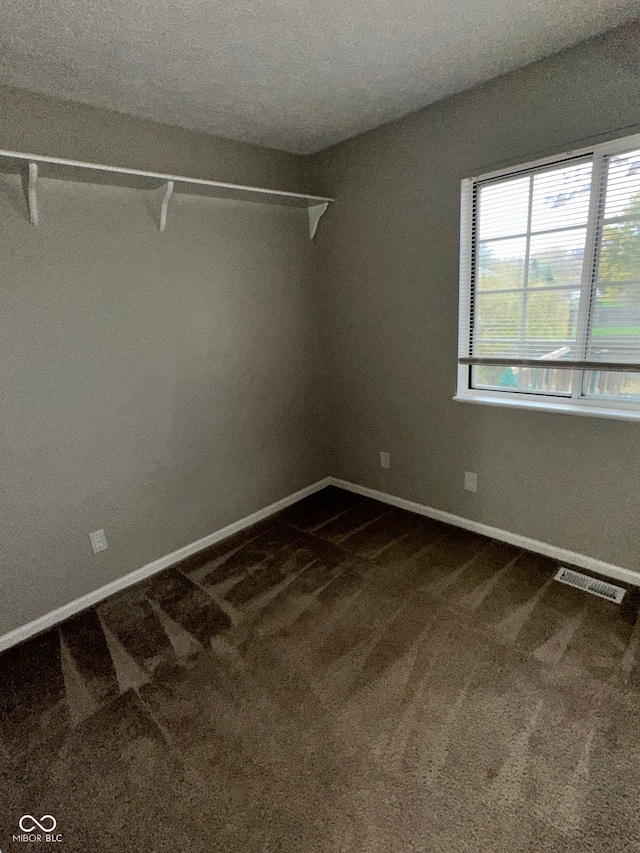 carpeted spare room featuring a textured ceiling