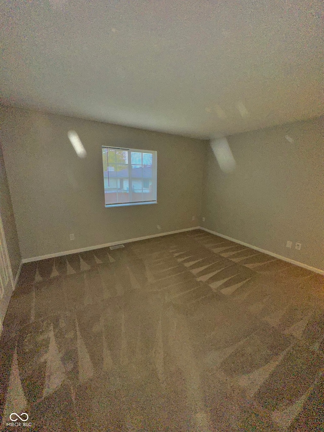 unfurnished room featuring a textured ceiling and carpet