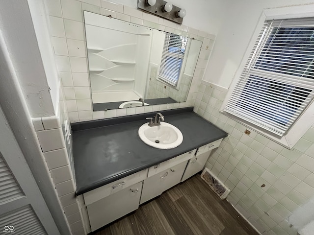 bathroom with vanity, tile walls, and hardwood / wood-style flooring