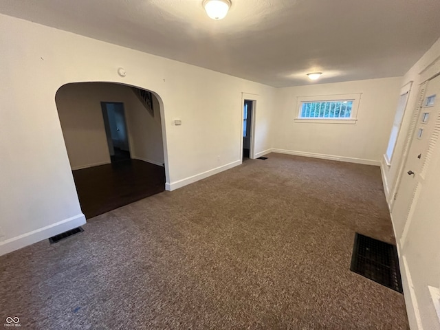 empty room with dark colored carpet