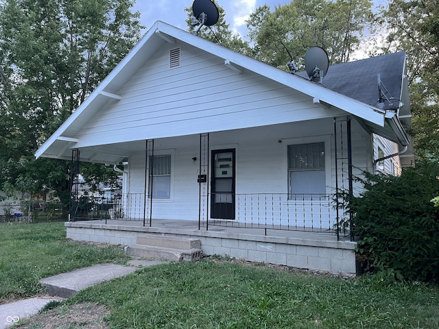 bungalow-style house with a front yard and covered porch