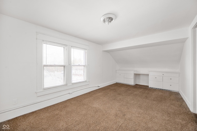 additional living space featuring lofted ceiling and carpet floors