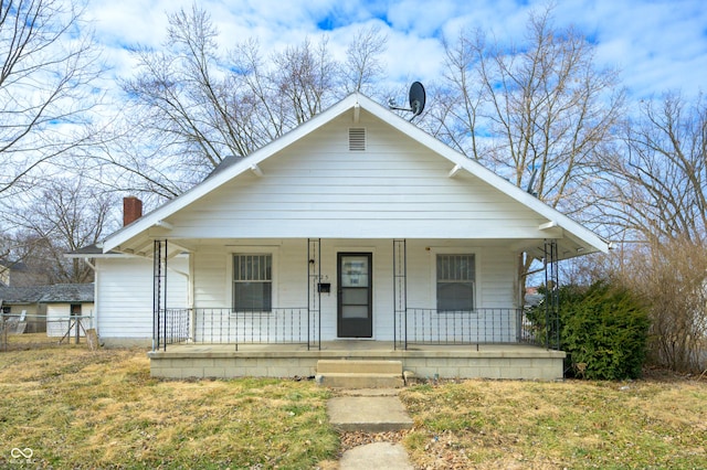 bungalow with a front yard and covered porch