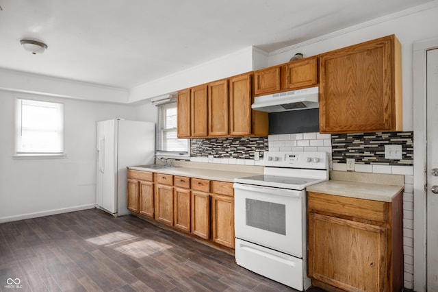 kitchen with sink, white appliances, dark wood-type flooring, ornamental molding, and decorative backsplash