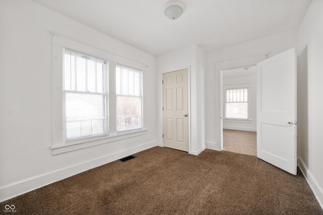 unfurnished bedroom with dark colored carpet