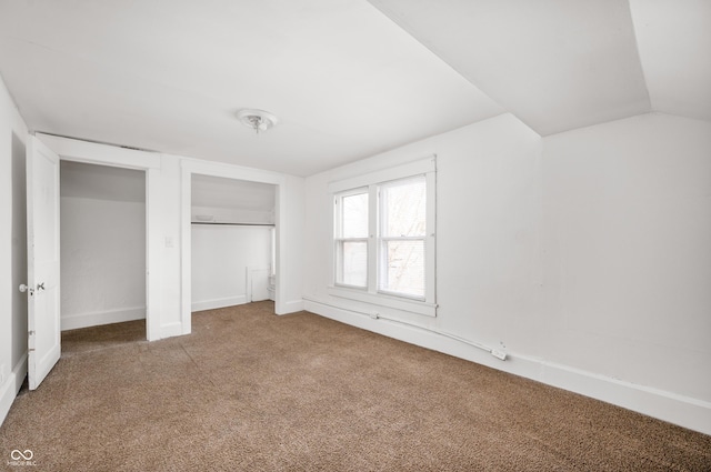 unfurnished bedroom with lofted ceiling, carpet floors, and a closet