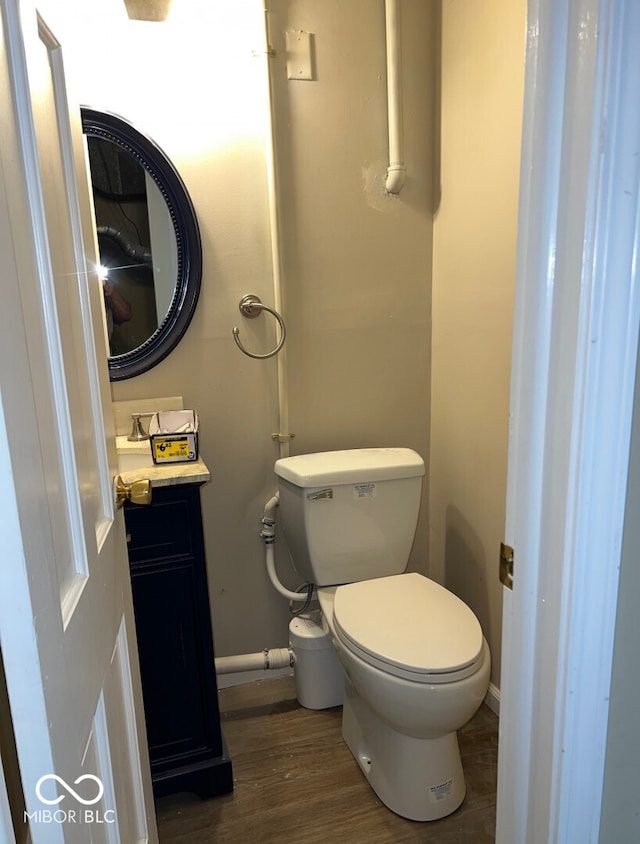 bathroom featuring toilet, vanity, and hardwood / wood-style floors