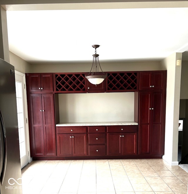 kitchen with pendant lighting, stainless steel refrigerator, and light tile patterned floors