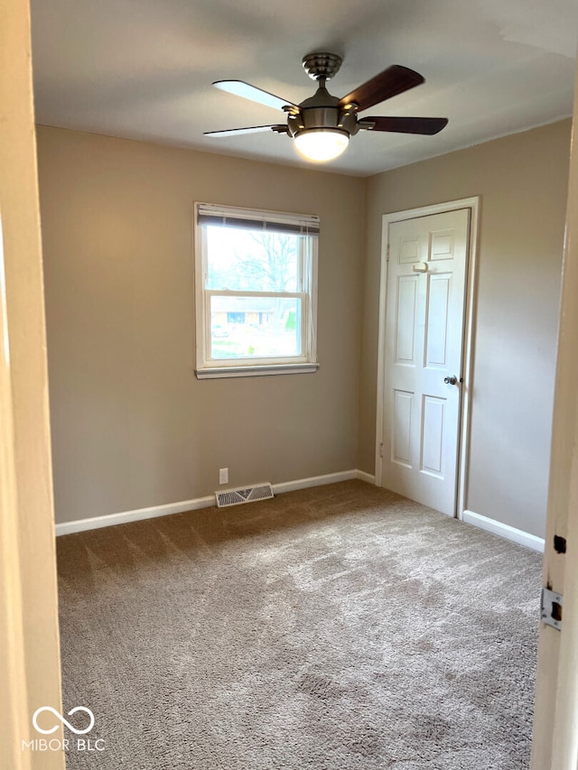 carpeted empty room featuring ceiling fan