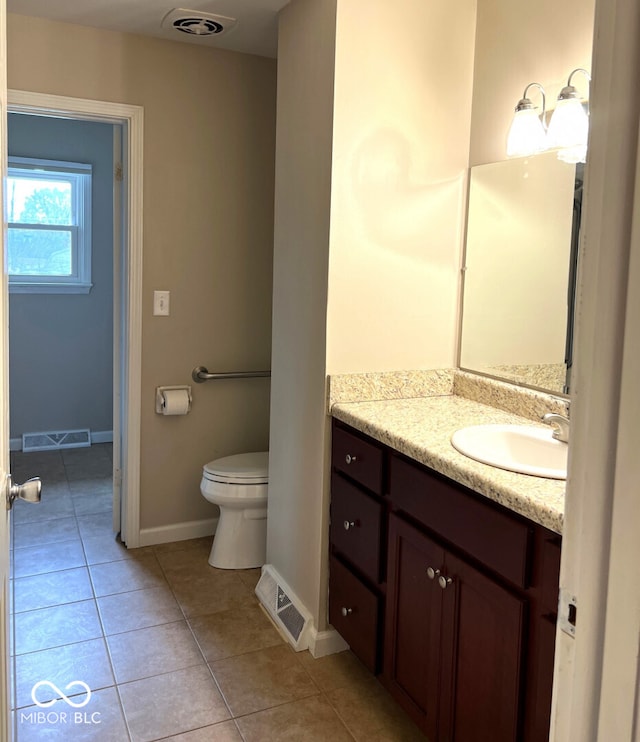 bathroom featuring toilet, vanity, and tile patterned flooring