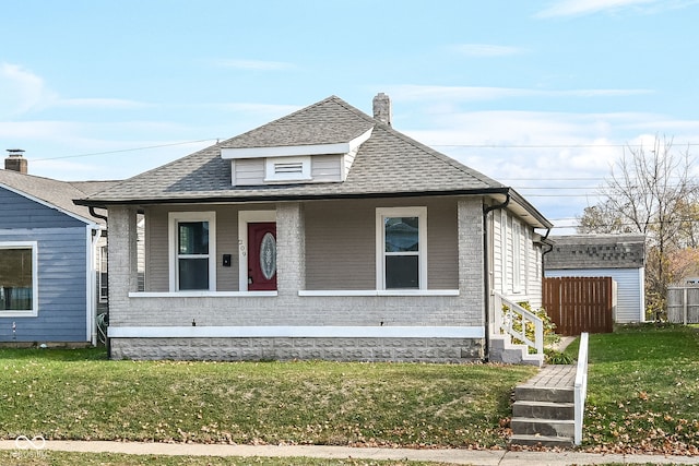 bungalow-style house with a front yard and a storage shed