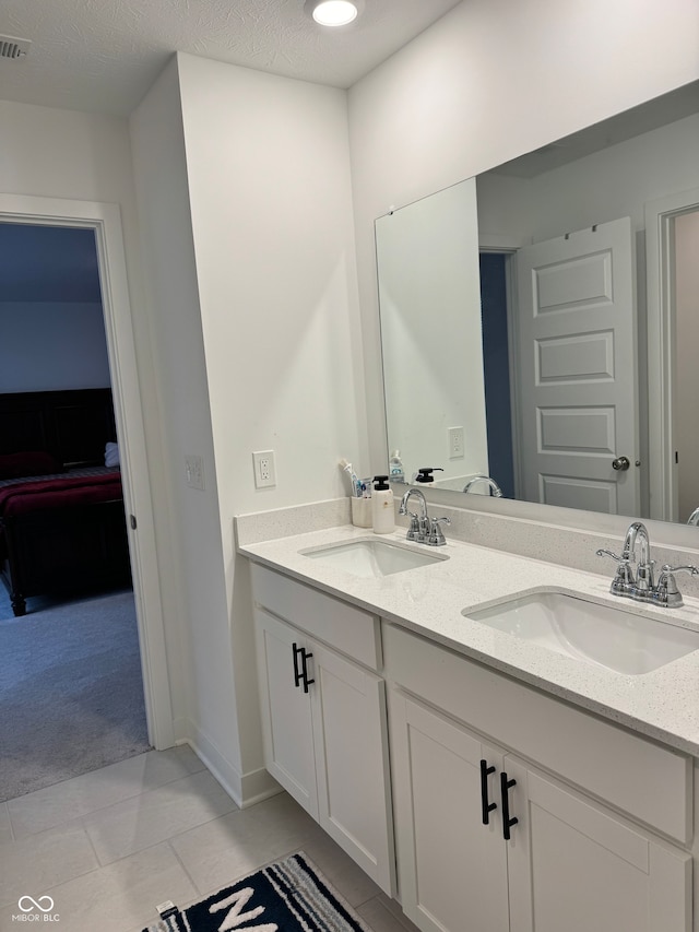 bathroom with tile patterned flooring, vanity, and a textured ceiling