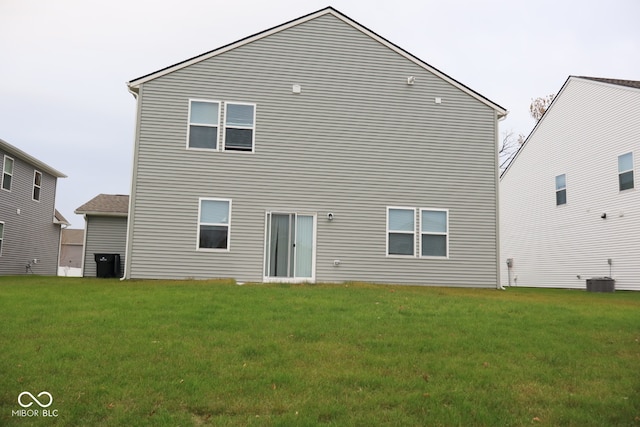 back of house featuring central air condition unit and a lawn