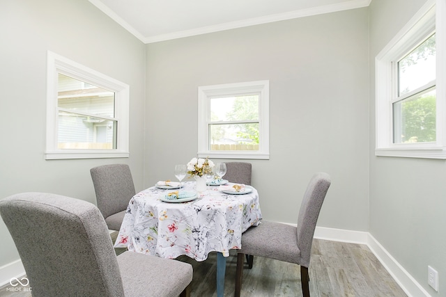 dining space with ornamental molding and wood-type flooring