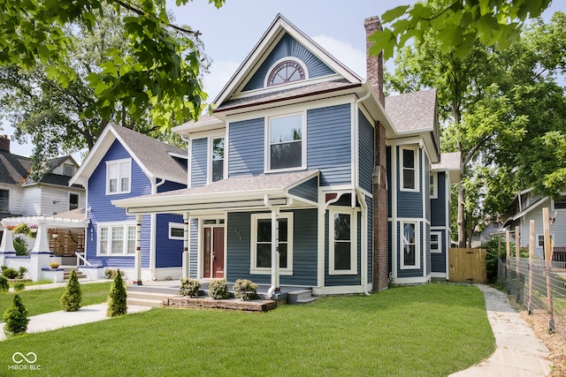 victorian house with a front yard and a pergola