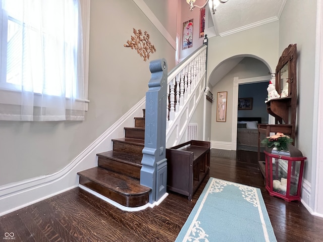 stairs with wood-type flooring and ornamental molding