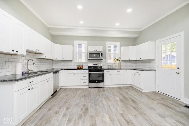 408 W 11th St, Anderson, IN 46016 - kitchen featuring stainless steel appliances, a sink, crown molding, tasteful backsplash, and light wood-type flooring