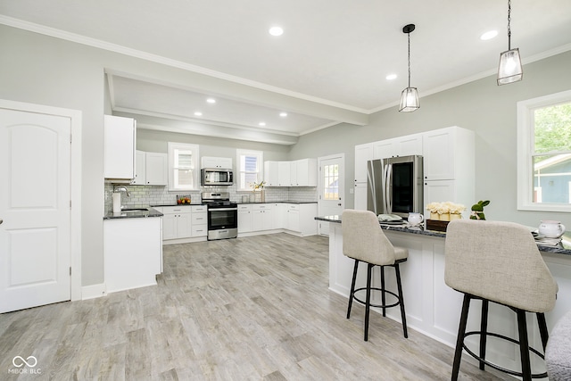 kitchen featuring stainless steel appliances, sink, crown molding, white cabinets, and light wood-type flooring