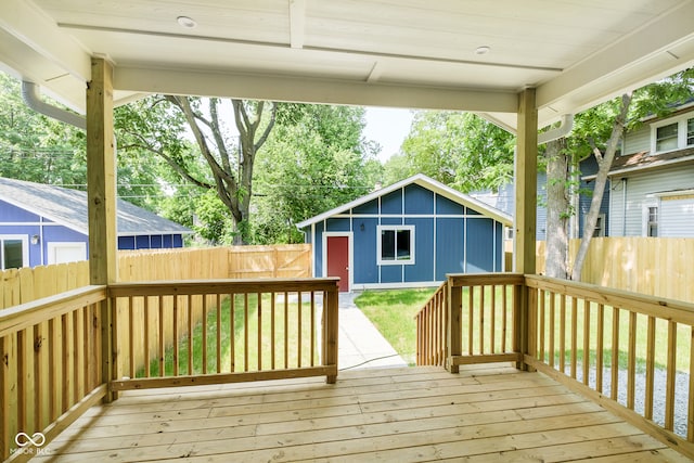 wooden deck with a lawn and an outdoor structure