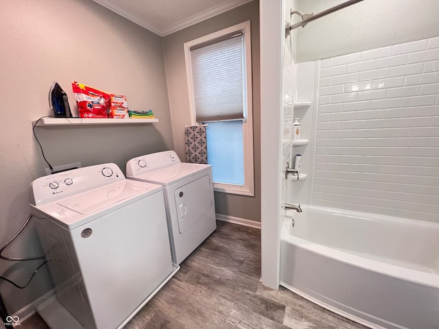 laundry area with hardwood / wood-style flooring, crown molding, and washer and clothes dryer