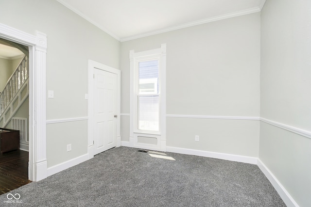 unfurnished room featuring dark colored carpet and ornamental molding