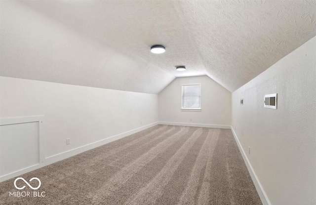 bonus room with lofted ceiling, carpet, and a textured ceiling