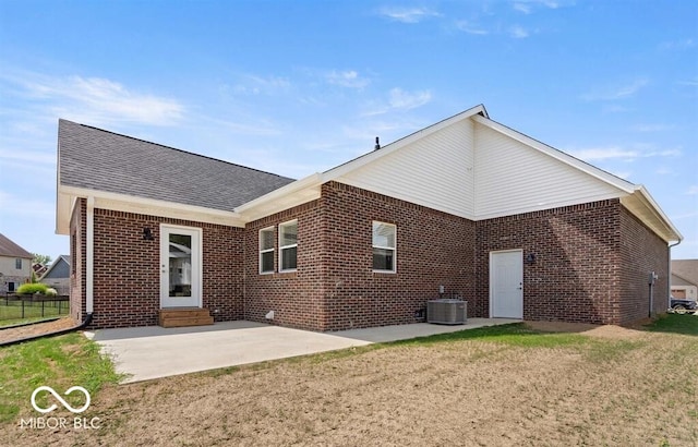 rear view of house featuring central AC unit, a patio area, and a yard